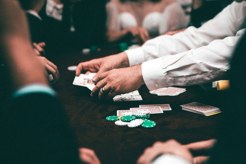 Pemain poker memegang kartu di meja permainan